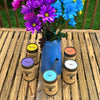 A display of FewwEssentials Dhoop Incense Sticks around Blue Flower Vase with colorful flowers. Items on Display: Joy, Life,Grace, Calm, and Clarity Dhoop Incense Sticks. 