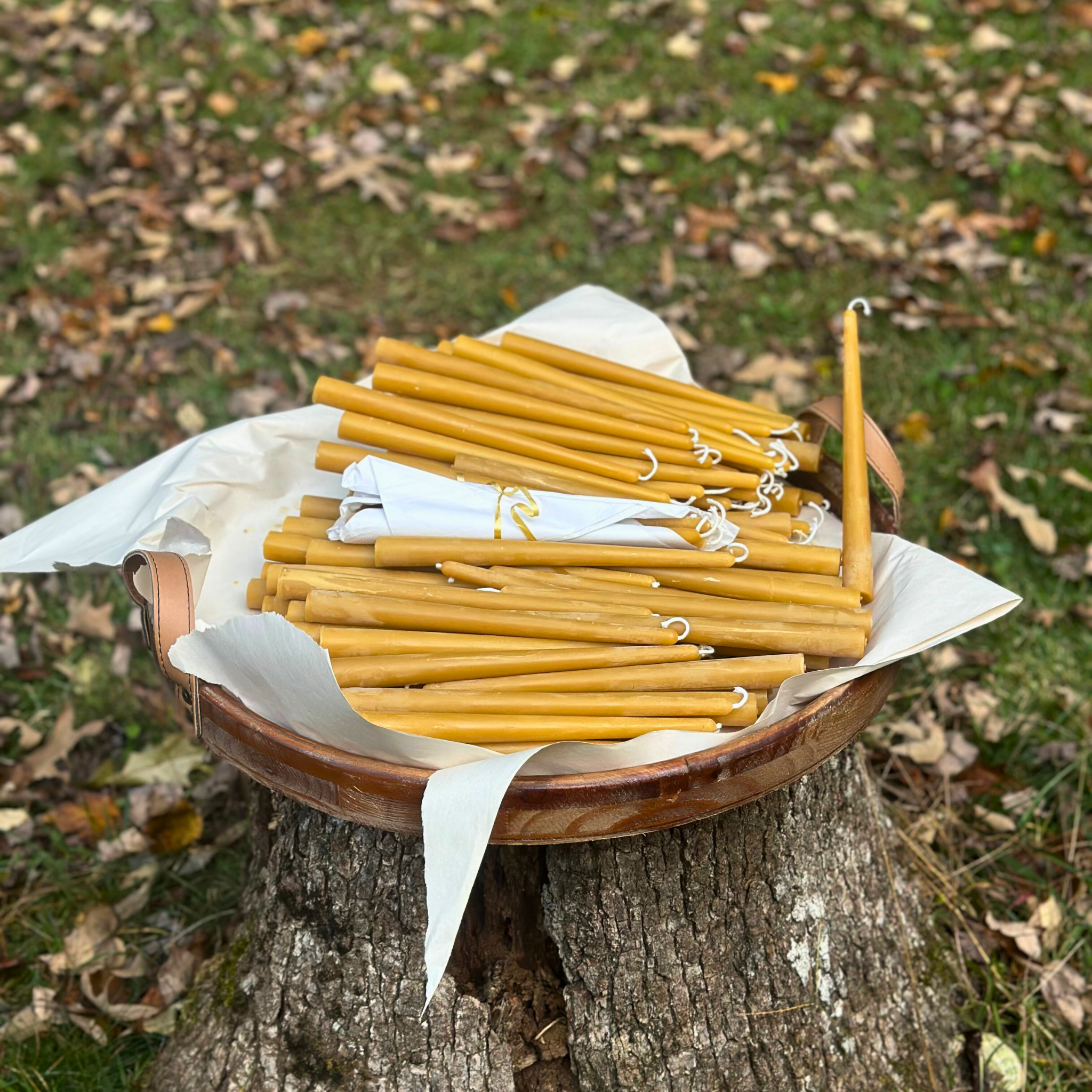FewwEssentials hand-dipped pure beeswax candles with cotton wicks, natural golden color, displayed outdoors