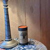 A FewwEssentials Dhoop Incense Stick labeled Grace placed on a table next to a decorative lamp and a floral-patterned tablecloth.